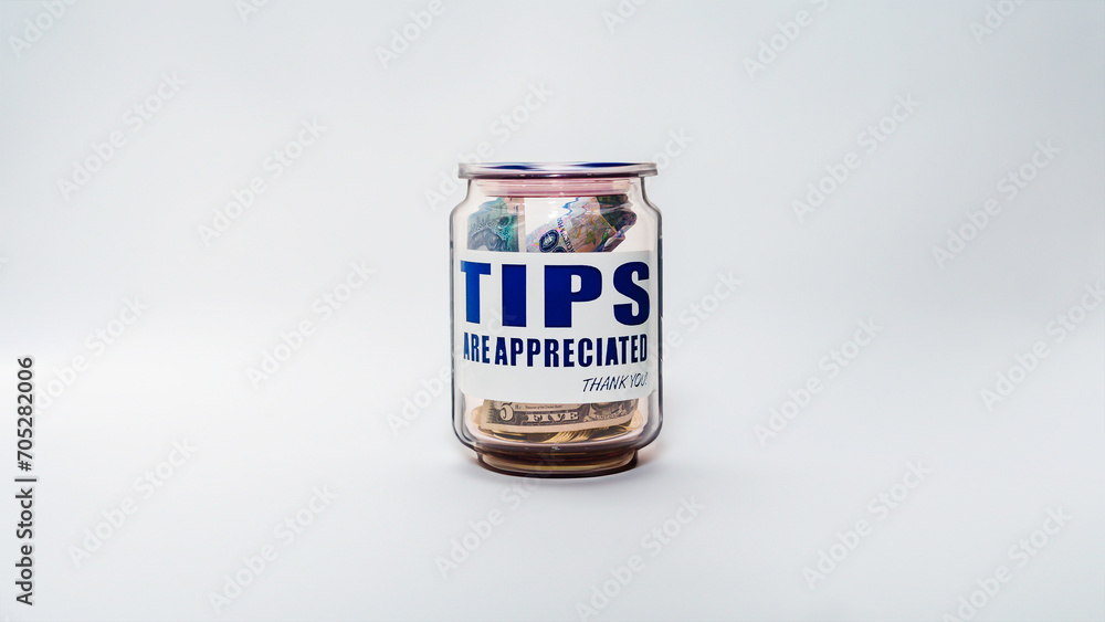 Jarro de propinas con billetes y monedas de varias denominaciones. Propinas de la industria de servicios, salario mínimo y concepto de propina como una forma única y creativa de almacenar dinero Jarro de propinas con billetes y monedas de varias denominaciones. Propinas de la industria de servicios, salario mínimo y concepto de propina como una forma única y creativa de almacenar dinero