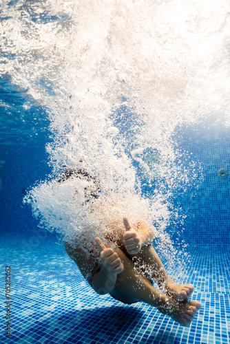 Little child swims underwater in swimming pool, happy active dives and has fun under water, kid fitness and sport 