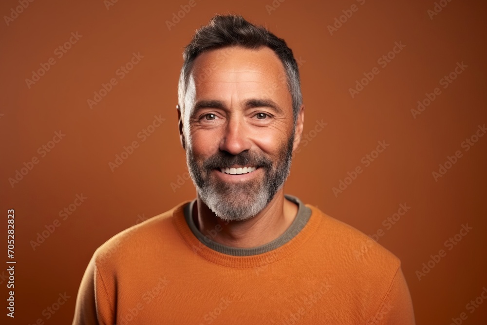 Portrait of a handsome middle-aged man smiling over brown background. Portrait of a handsome middle-aged man smiling over brown background.