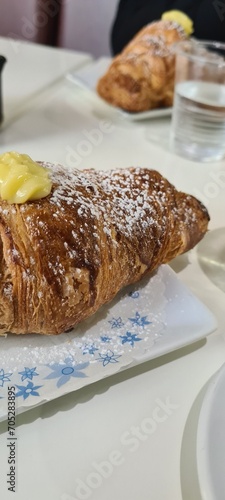 particolare di un cornetto italiano con crema e zucchero a velo