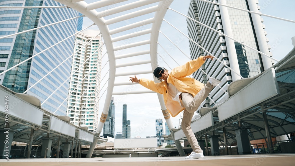 Stylish asian man perform hiphop dancing with low angle camera. Break dancer walking up the stair while listening music from headphone and dancing together at city. Outdoor sport 2024. Sprightly.