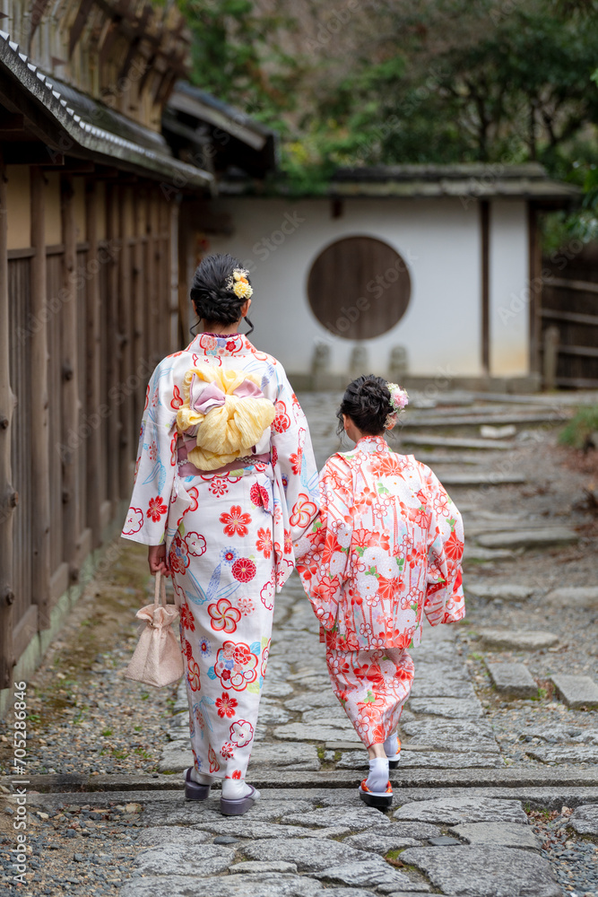 Fototapeta premium Two girls wearing Japanese traditional Kimono walking on the street. Kyoto, Japan.
