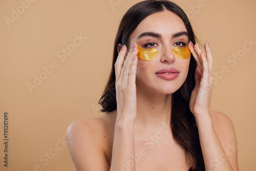 Canvastavla Woman standing naked isolated looking camera take care of her skin with under ey
