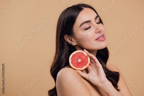 Young Woman Holding Grapefruit Applying Eye Cream Drops On Skin Under Eyes