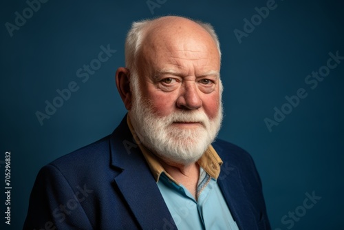 Portrait of an old man on a blue background. Studio shot.