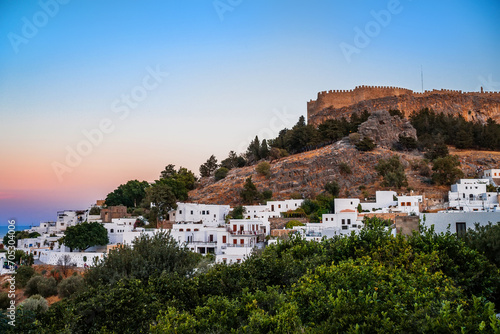 Evening view of the ancient Acropolis of Lindos and snow white houses.