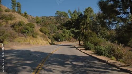 POV wide shot of car Driving rural road Hollywood hill to sign and observatory. California, USA