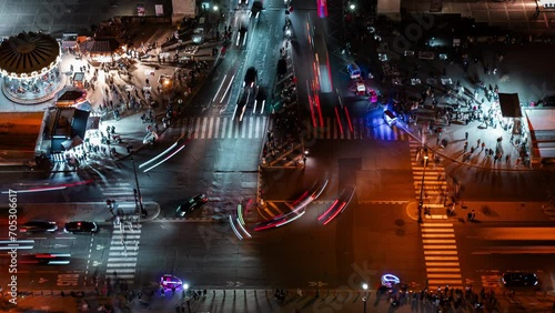 Timelapse of traffic and pedestrians crossing a busy intersection in Paris city center at night, view from above, France