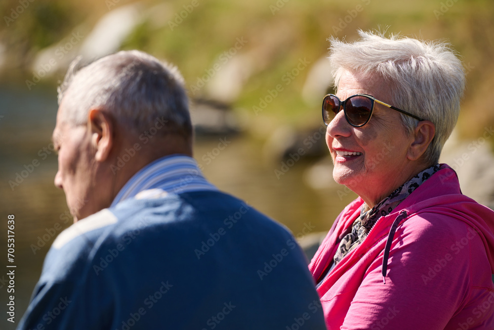 Obraz premium Elderly couple finding solace and joy as they rest on a park bench, engaged in heartfelt conversation, following a rejuvenating strol a testament to the enduring companionship and serene connection