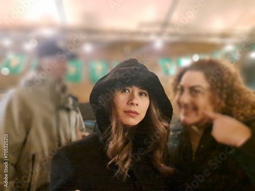 Striking Asian woman stands out in crowd with black hood.