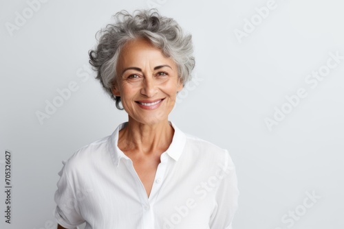 Portrait of a happy senior woman looking at camera over grey background