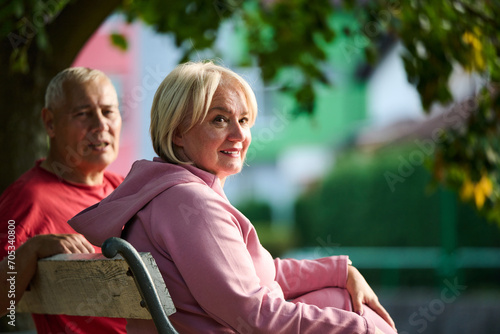 Elderly couple finding solace and joy as they rest on a park bench, engaged in heartfelt conversation, following a rejuvenating strol a testament to the enduring companionship and serene connection