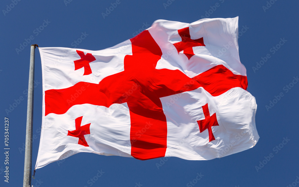 Fototapeta premium National flag of Georgia against the blue sky.