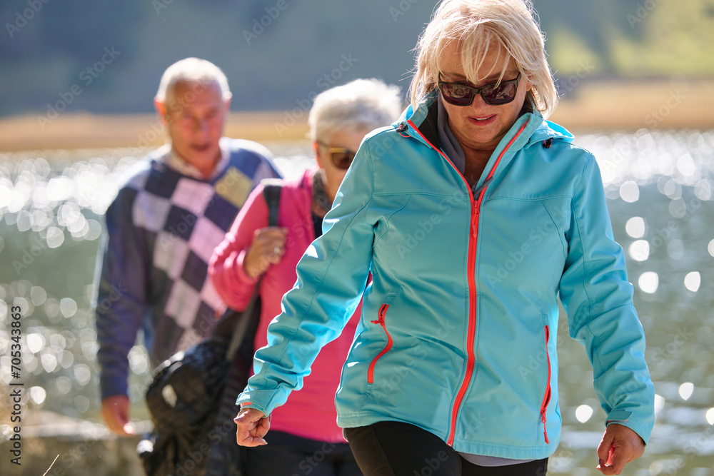 Obraz premium A family shares delightful moments with their friends amid the stunning landscapes of mountains, lakes, and winding paths, promoting a healthy lifestyle and the joy of familial bonds in the embrace of