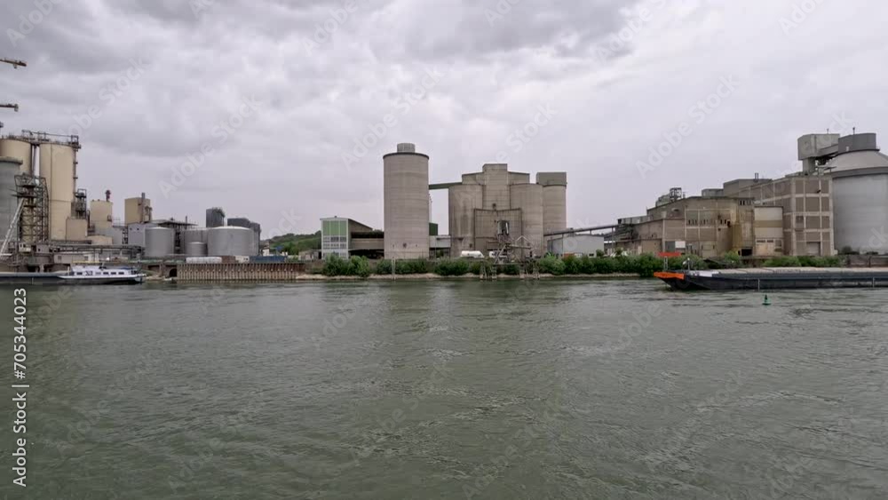 Factory Scene with Industrial Building and Equipment on the Rhine River. Large silo towers in the center of view. Located just south of Mainz, Germany in Bleiau, Germany. Factory Scene with Industrial Building and Equipment on the Rhine River. Large silo towers in the center of view. Located just south of Mainz, Germany in Bleiau, Germany.