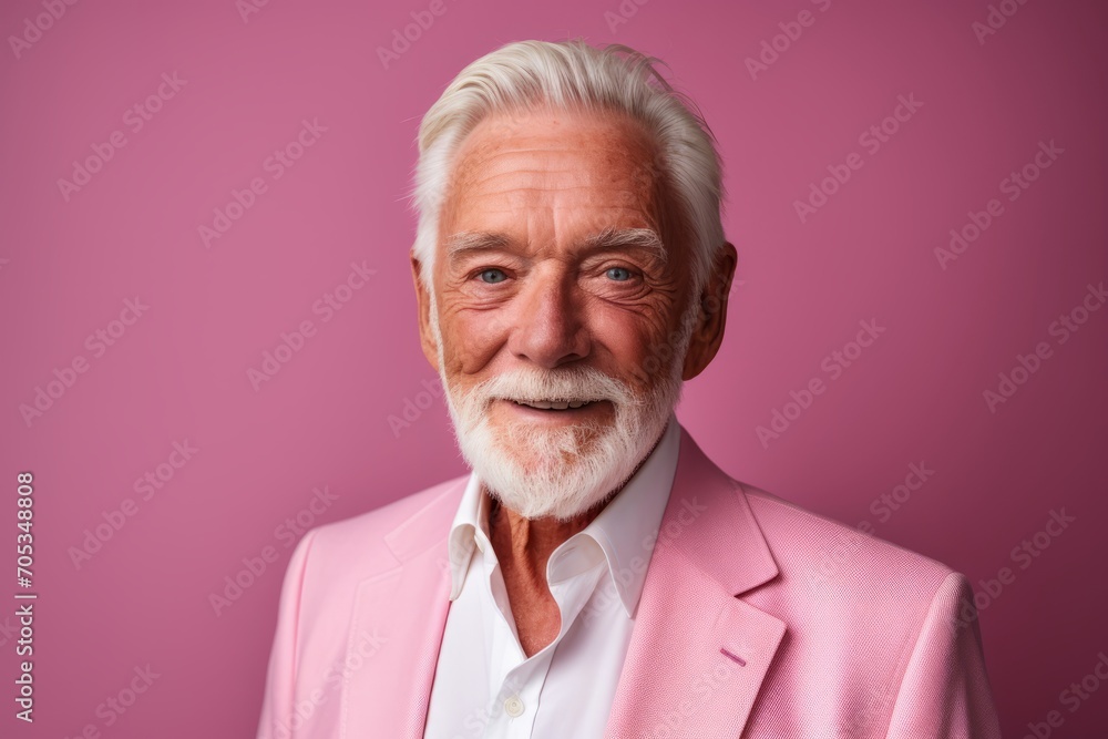Portrait of a senior man in a pink suit on a pink background. Portrait of a senior man in a pink suit on a pink background.