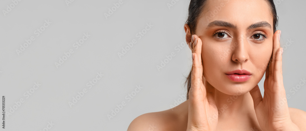 Pretty young woman with healthy skin on grey background with space for text Pretty young woman with healthy skin on grey background with space for text