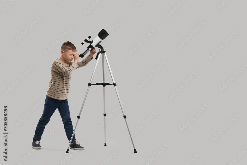 Little boy looking at stars through telescope on light grey background, space for text
