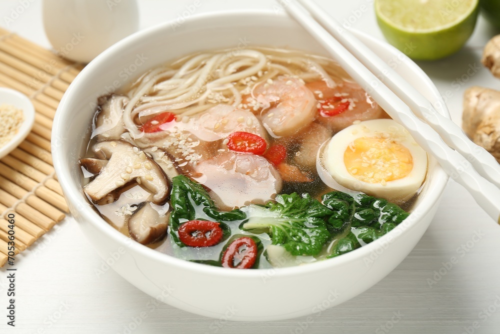 Tasty ramen with shrimps in bowl and chopsticks on white table, closeup Tasty ramen with shrimps in bowl and chopsticks on white table, closeup