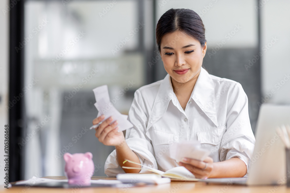 asian woman using calculator and calculate bills in home office. tax form us business income office Financial document. Tax time.Tax concept.