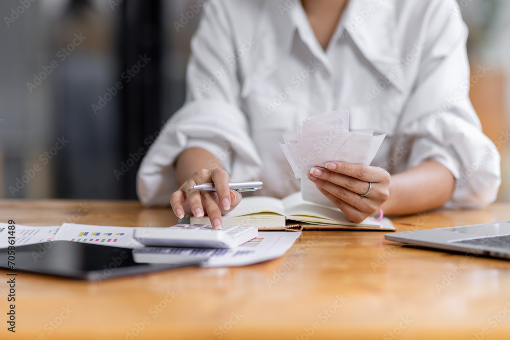 asian woman using calculator and calculate bills in home office. tax form us business income office Financial document. Tax time.Tax concept.