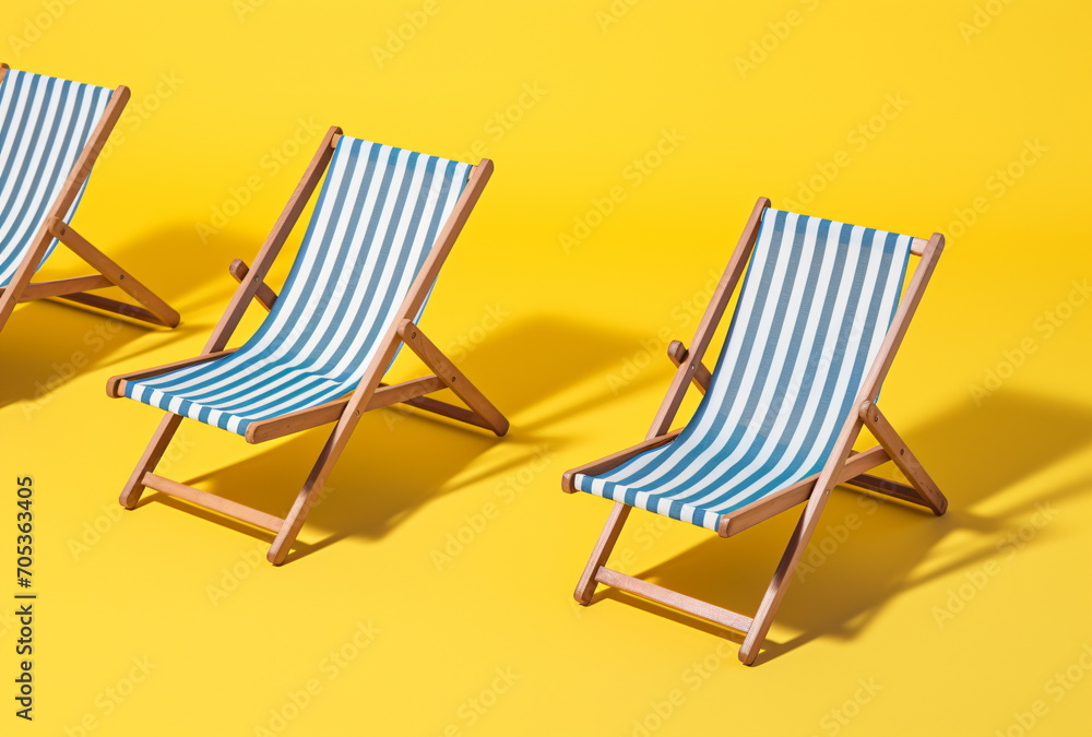 Deckchair with blue and white striped pattern isolated on yellow studio background with shadow of deckchair. Summer vacation travel relaxation concept. Generative AI