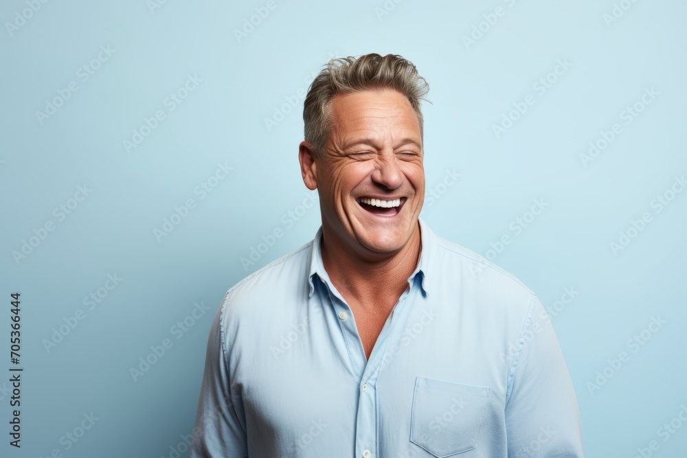 Portrait of a happy mature man laughing against a blue background. Portrait of a happy mature man laughing against a blue background.