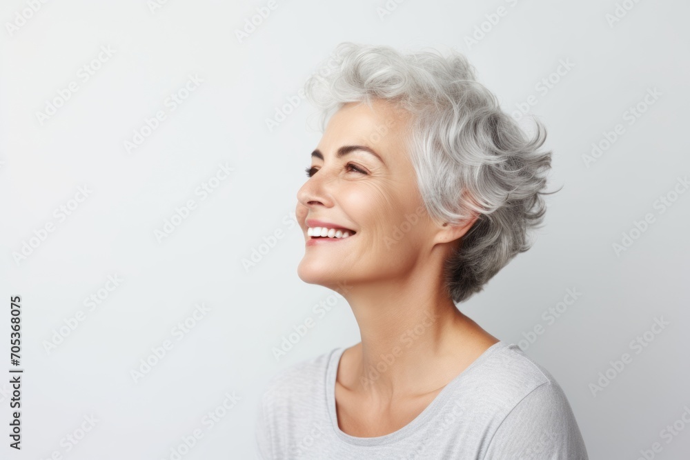 Portrait of happy smiling senior woman with grey hair over grey background