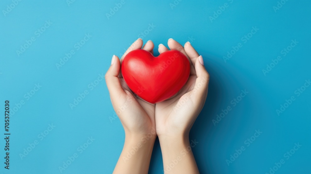 Fototapeta premium hands hold a red heart on a blue background AI generated