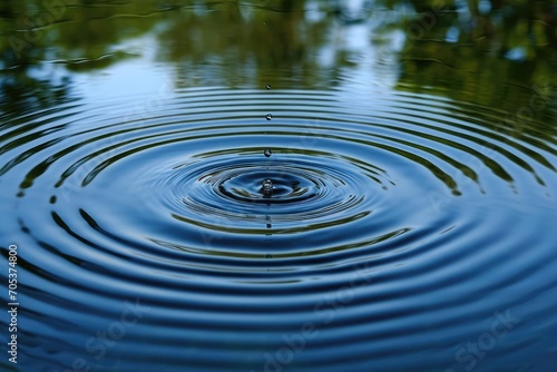 Single drop of water creating ripples on a still pond