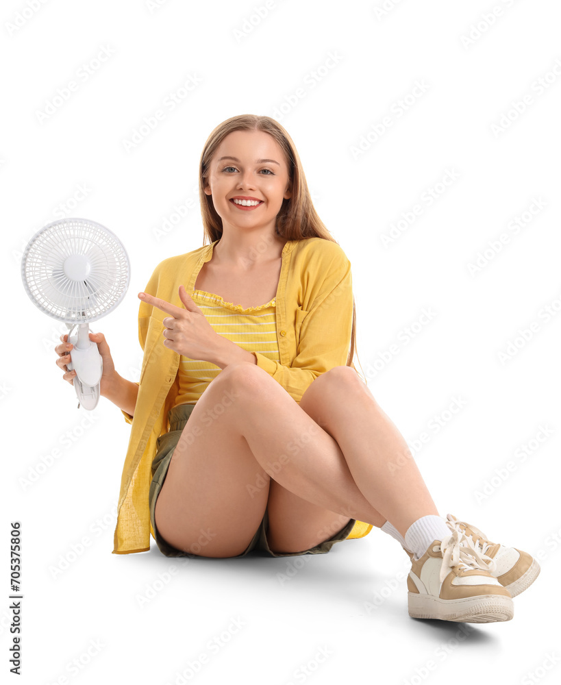 Young woman pointing at electric fan on white background Young woman pointing at electric fan on white background