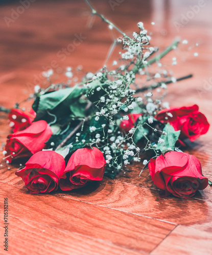 Red roses on hardwood floor. photo