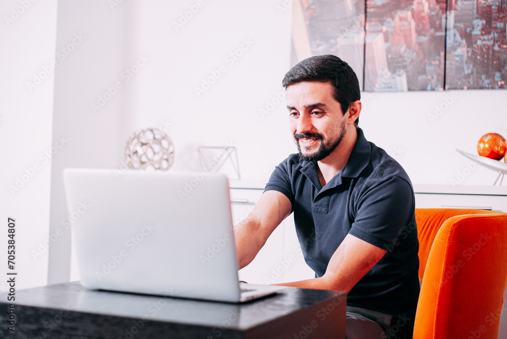 businessman working on his computer, smiling in a room businessman working on his computer, smiling in a room