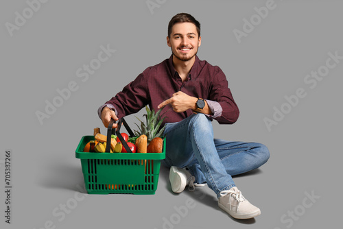 Young man pointing at shopp...