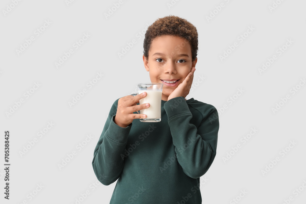 Little African-American boy with glass cup of milk on white background Little African-American boy with glass cup of milk on white background
