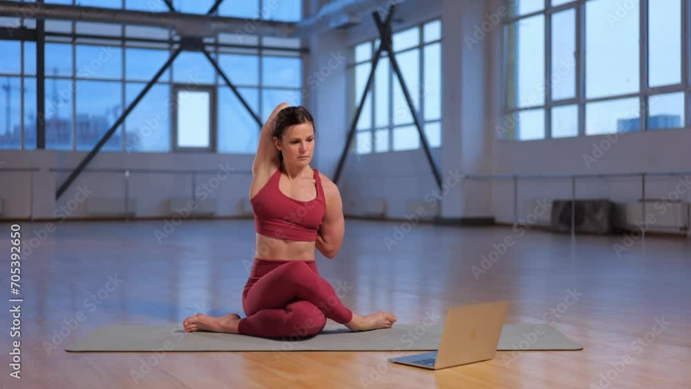 athletic girl teaches an online lesson yoga asana with laptop athletic girl teaches an online lesson yoga asana with laptop