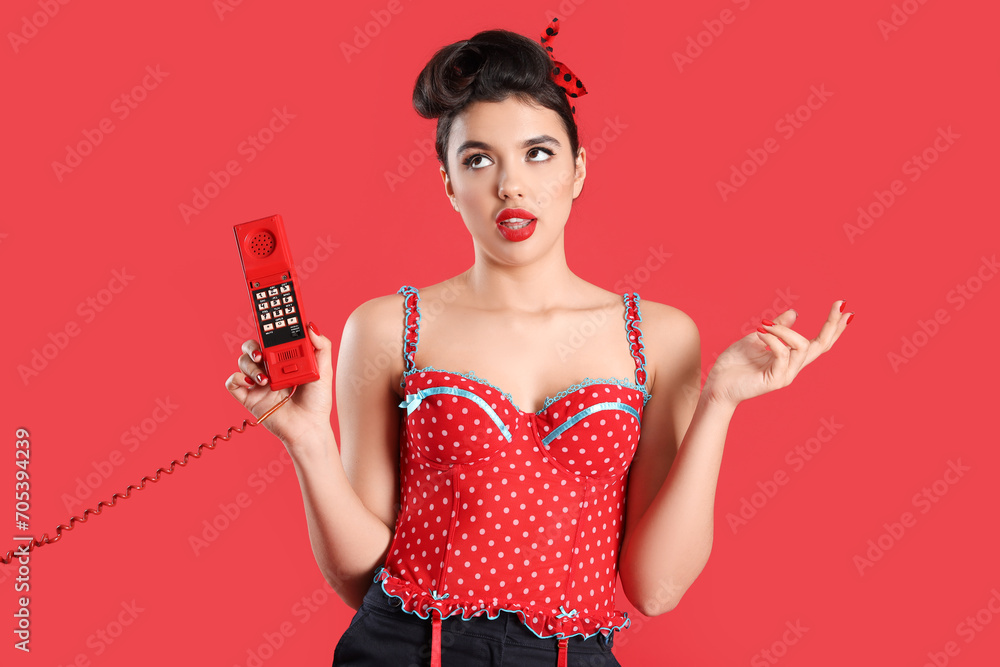Young pin-up woman with phone receiver on red background Young pin-up woman with phone receiver on red background