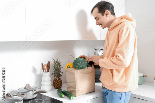 Young man with paper bag of...