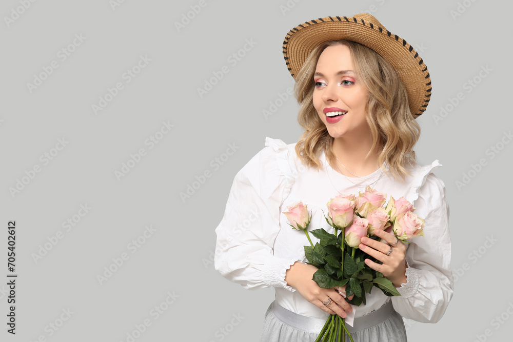 Pretty young woman with bouquet of beautiful roses on grey background Pretty young woman with bouquet of beautiful roses on grey background