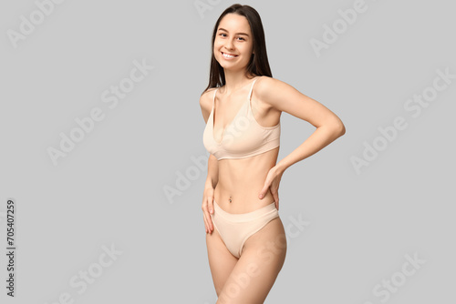 Beautiful young woman in underwear on grey background. Epilation concept