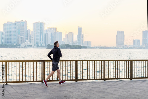 Middle age man wearing sportswear running at seaside. Healthy lifestyle, active city life concept. © Sergey