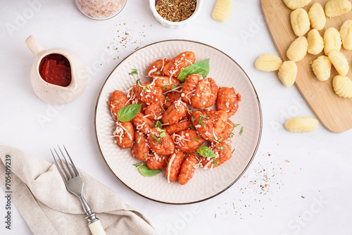 Plate of tasty gnocchi with cheese on white background