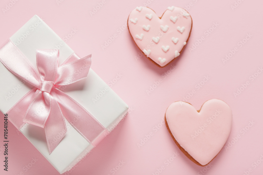 Tasty heart shaped cookies with gift box on pink background. Valentine's Day celebration