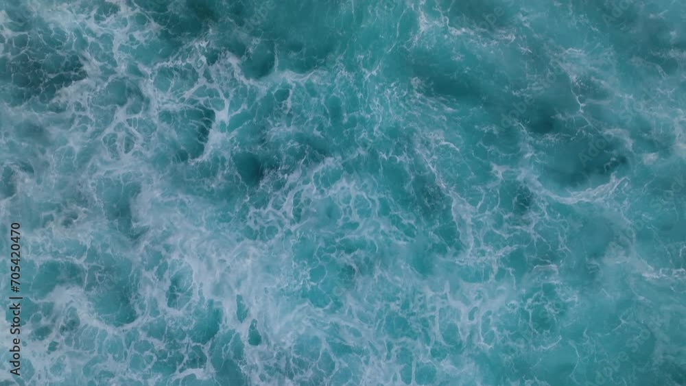 Top down aerial view of beautiful giant blue ocean waves crashing and foaming with whitewash background Top down aerial view of beautiful giant blue ocean waves crashing and foaming with whitewash background