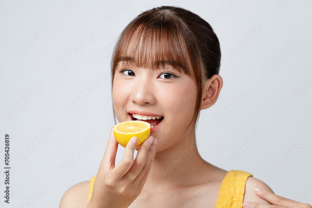 Woman eating lemon on white background, space for text Woman eating lemon on white background, space for text