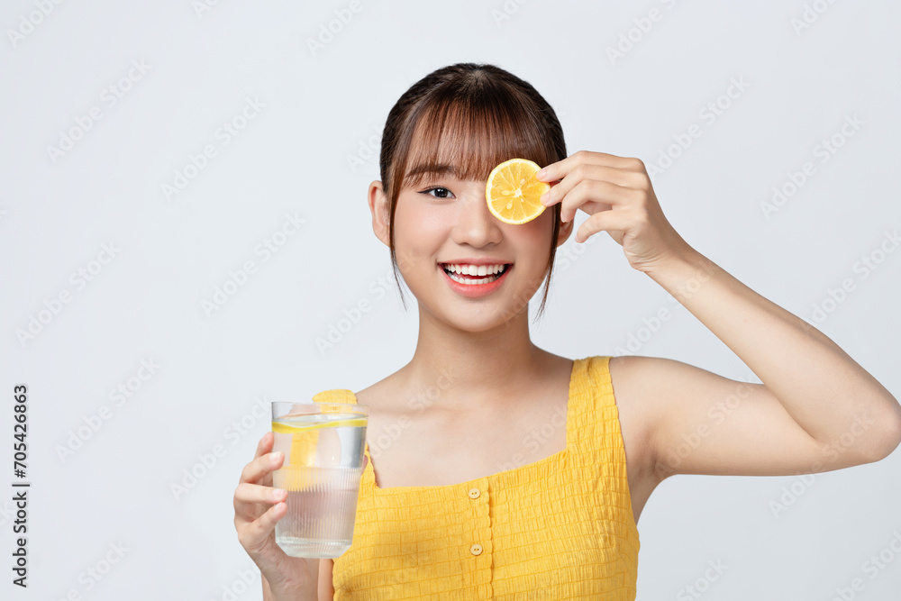 Beautiful young woman with healthy, well-kept skin taking care after health, drinking water with lemons Beautiful young woman with healthy, well-kept skin taking care after health, drinking water with lemons