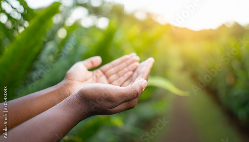 Hands in prayer, open in respect, against serene nature backdrop © Your Hand Please