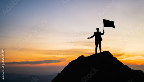 Silhouette businessman atop mountain holds blank flag, symbolizing success, leadership, and opportunity in bright sunlight © Your Hand Please