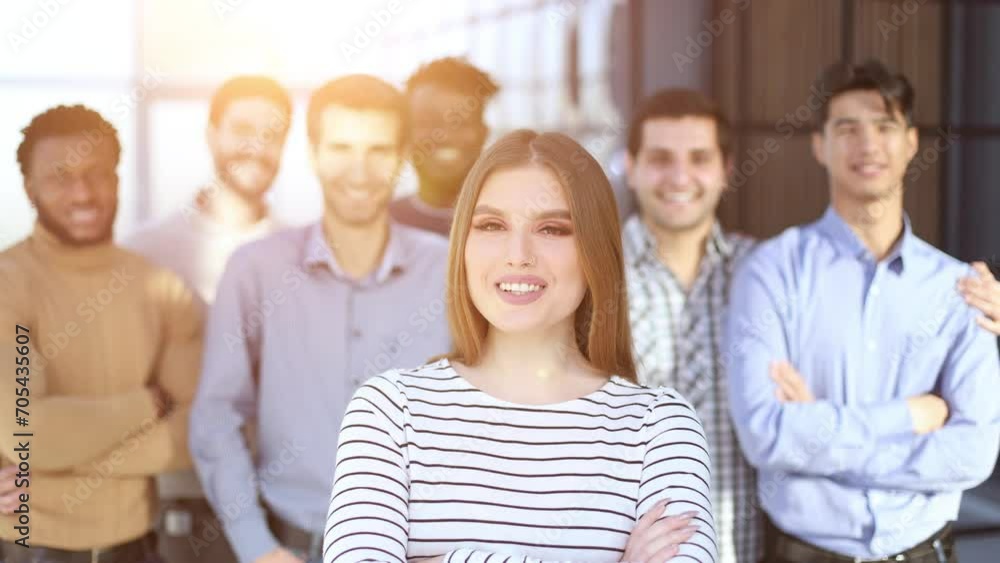 Successful millennial business woman stands at the forefront of a multiethnic team Successful millennial business woman stands at the forefront of a multiethnic team