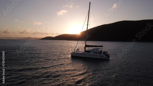 Catamaran in calm waters of Hook Island reef between Nara and Macona Inlets in Whitsunday Islands during Golden Hour Sunset, Queensland, Australia